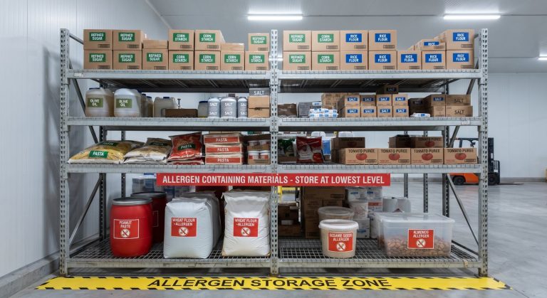 Warehouse racking with allergen-containing materials stored at the lowest level in a marked allergen storage zone