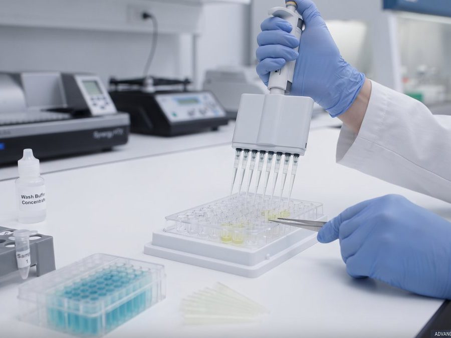 Analyst running an ELISA plate for allergen testing in the laboratory Analyst running an ELISA plate for allergen testing in the laboratory
